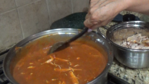 Stirring the chicken into the mole sauce